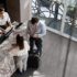 Black manager and recepcionist checking in a couple and man looking at his smartphone at the hotel